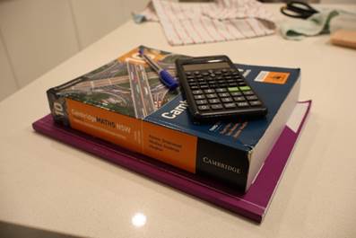 A calculator and a book on a table

AI-generated content may be incorrect.